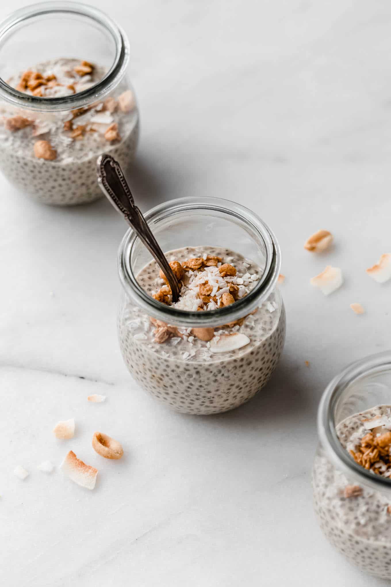 three jars of peanut butter chia pudding topped with peanut granola