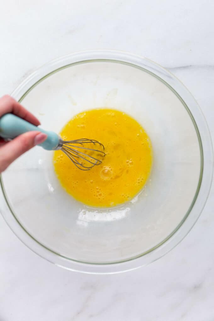 eggs being whisked in a mixing bowl.