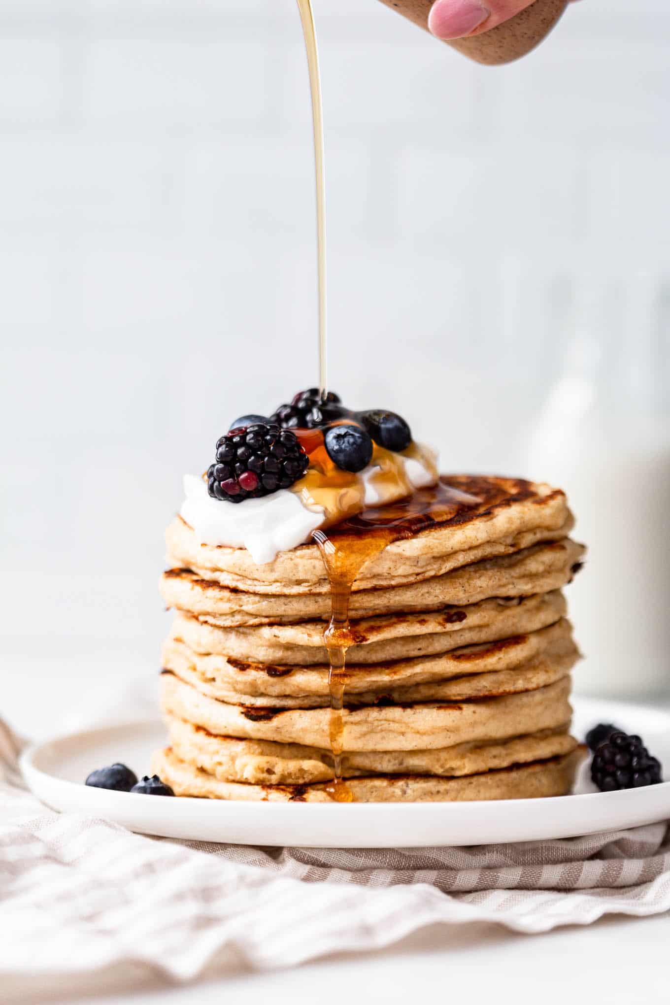 maple syrup being poured onto cottage cheese pancakes