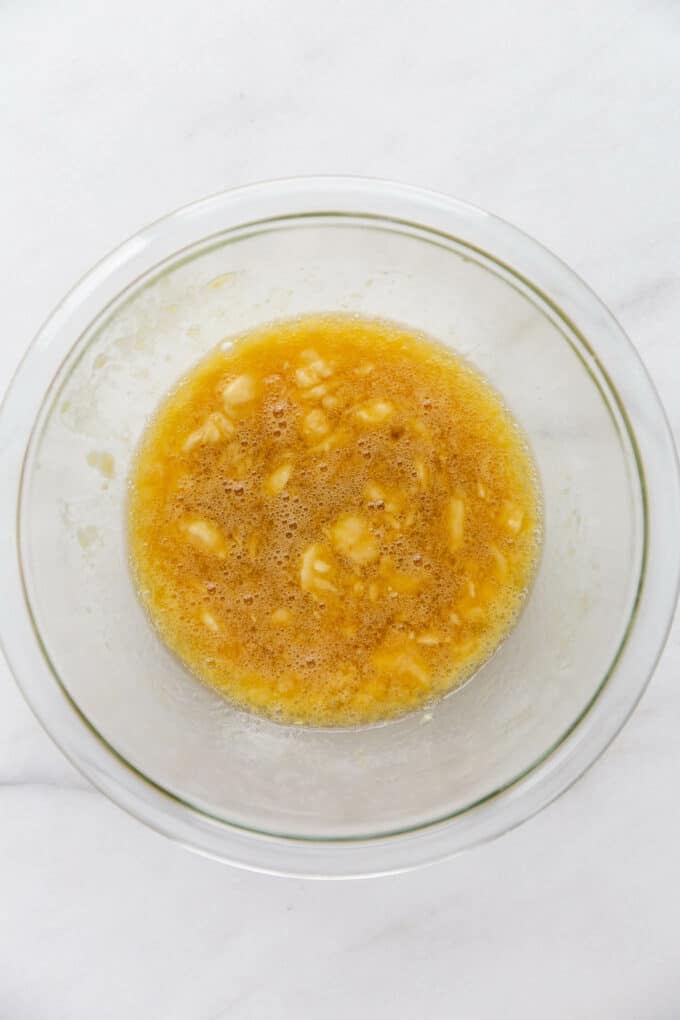 mashed banana, egg, oil and maple syrup in a mixing bowl