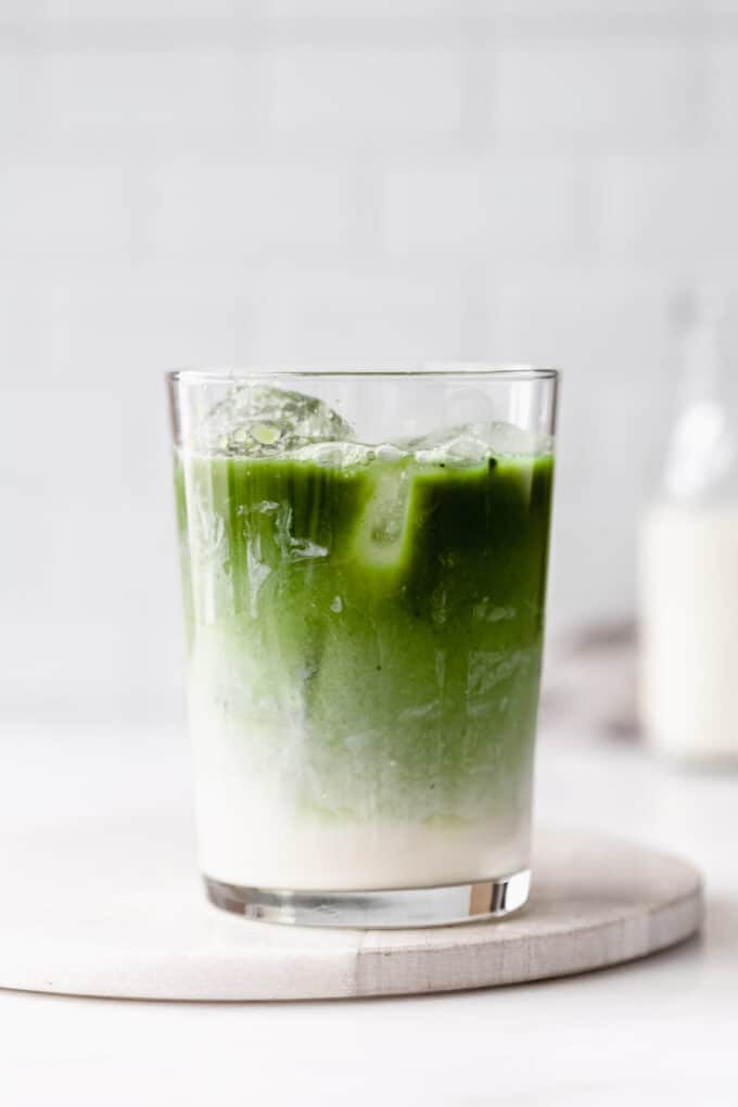 a glass of iced matcha latte on a marble board