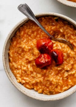 a bowl of tomato risotto topped with roasted tomatoes