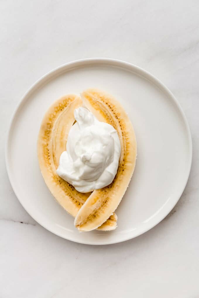 a sliced banana with yogurt on top