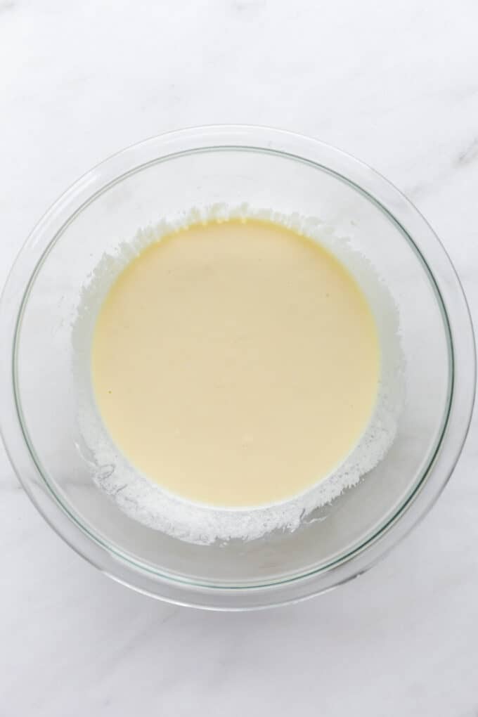 whisked up eggs and greek yogurt in a mixing bowl