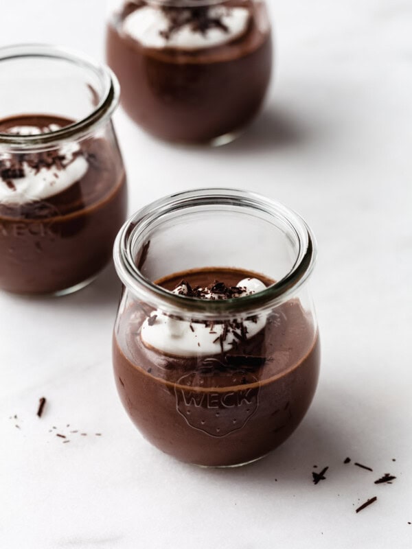 three cups of vegan chocolate pudding topped with yogurt