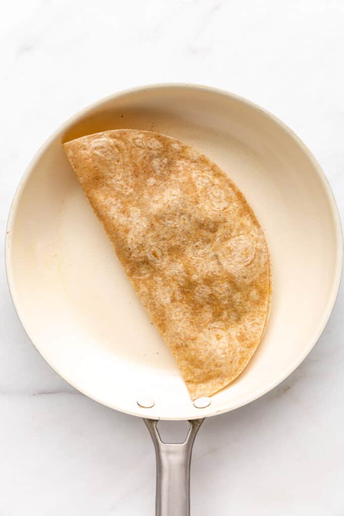 a tortilla folded in half in a pan