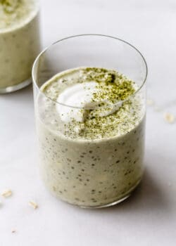 a cup of matcha overnight oats topped with yogurt and matcha powder