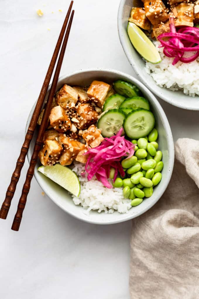 A peanut tofu bowl with wood chopsticks