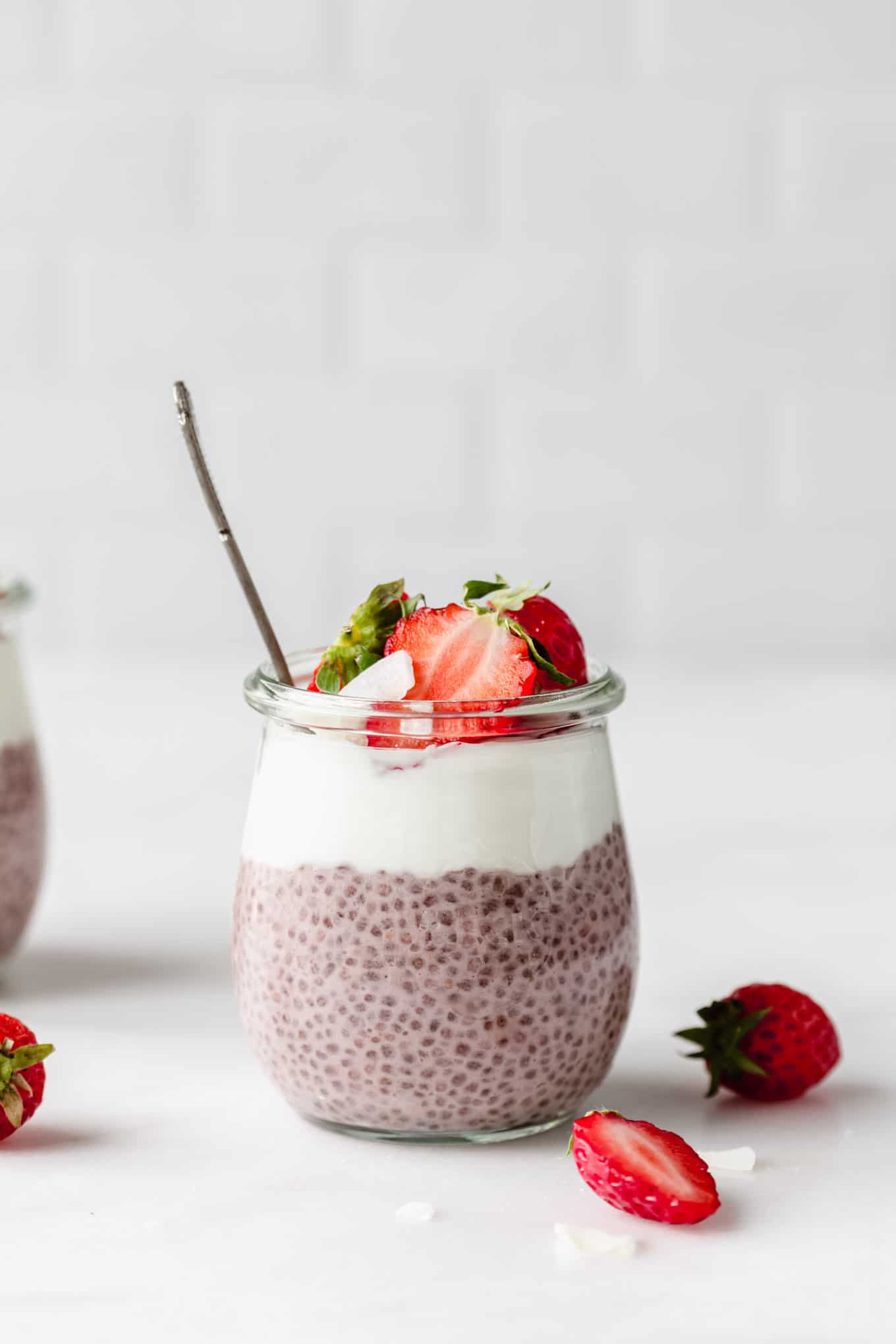 a jar of strawberry chia pudding topped with yogurt and strawberries