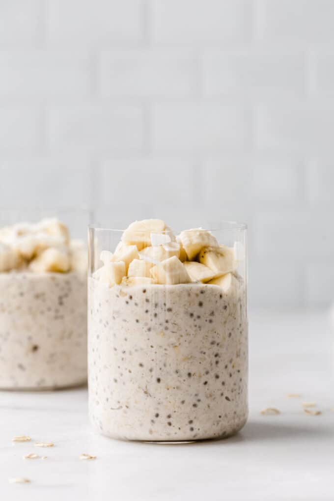 two cups of banana overnight oats topped with banana.