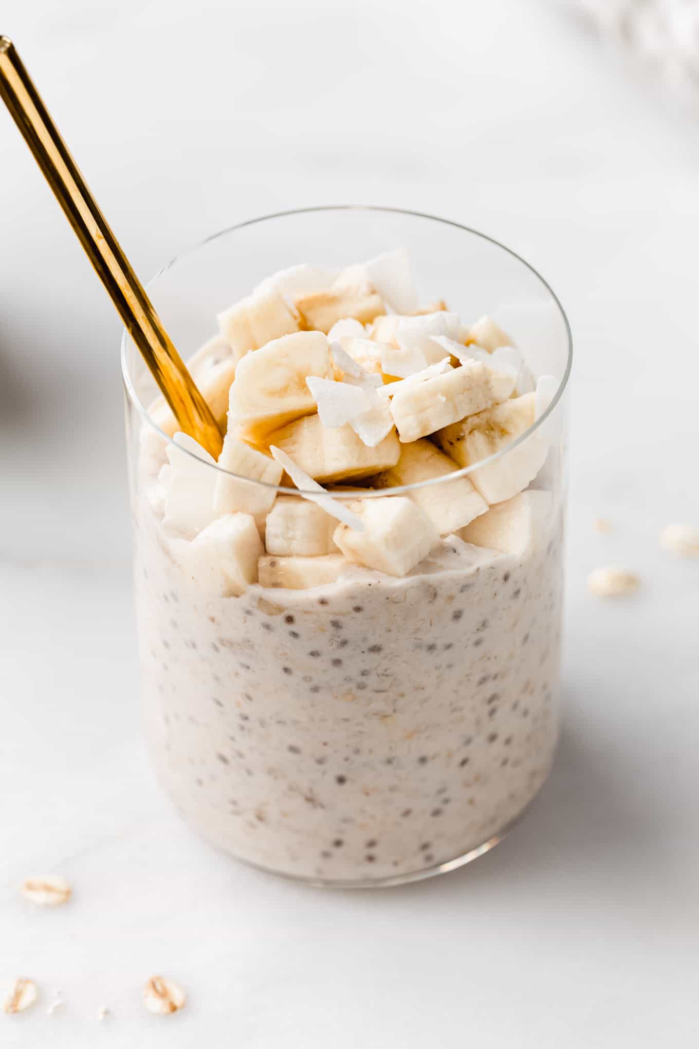 banana overnight oats in a cup with a gold spoon