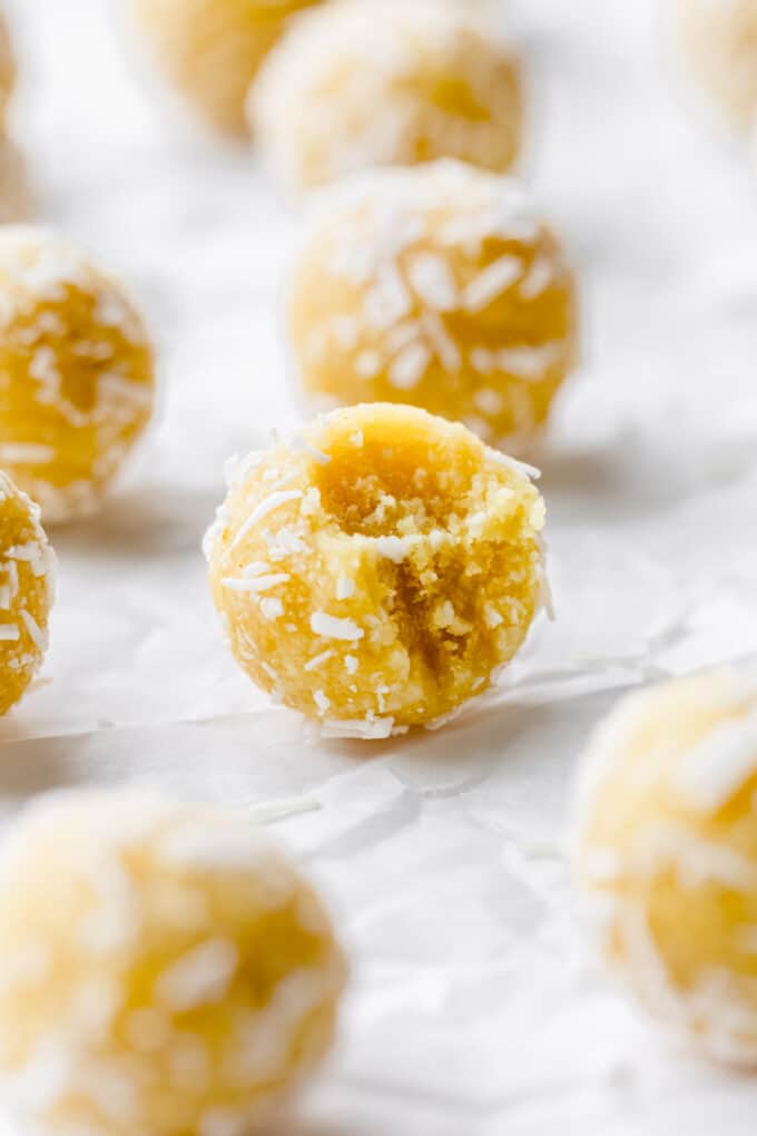 a lemon bliss ball with a bite taken out of it