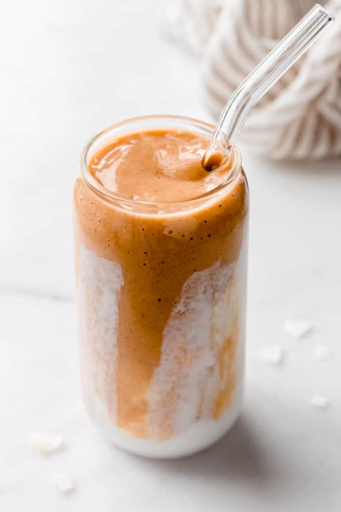 a papaya smoothie in a glass with coconut milk