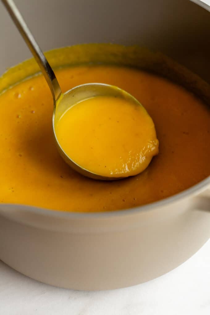 a ladle spooning out acorn squash soup