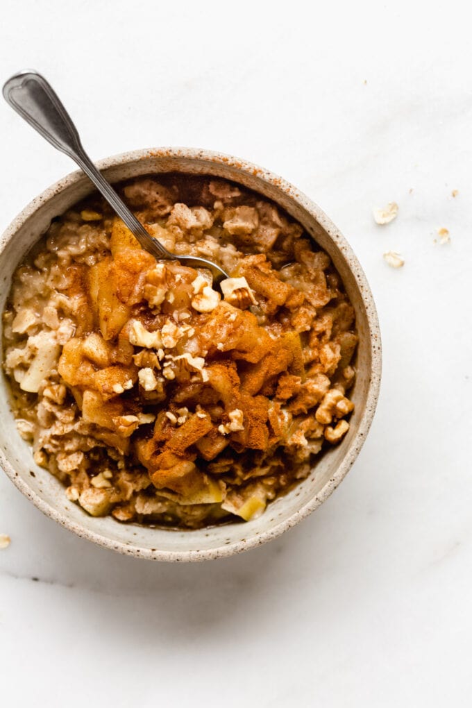 cinnamon apple pie oatmeal with a spoon in a bowl