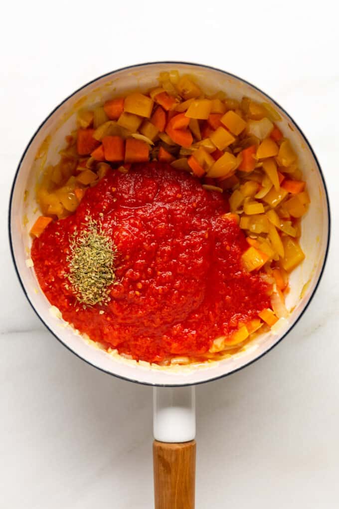 chopped vegetables, crushed tomatoes and dried herbs in a pot