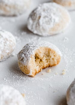 an almond snowball cookie with a bite taken out of it