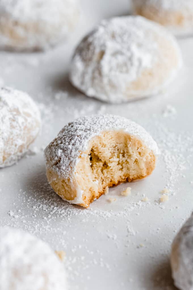 an almond snowball cookie with a bite taken out of it