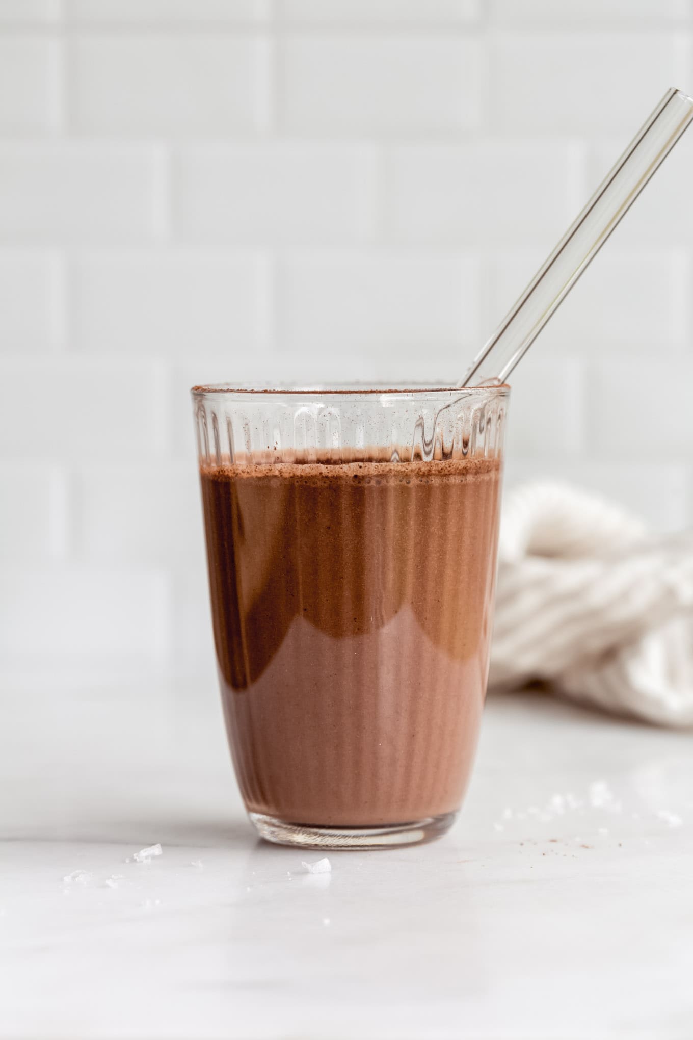 chocolate banana smoothie in a class on a marble counter