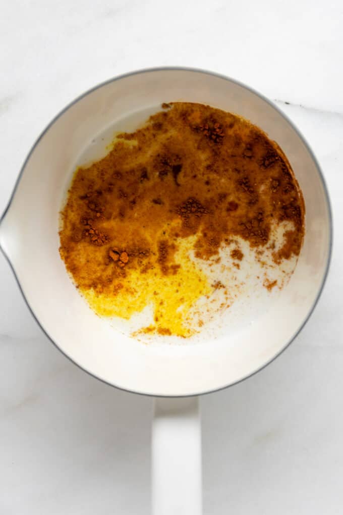 spices and almond milk in a white pot