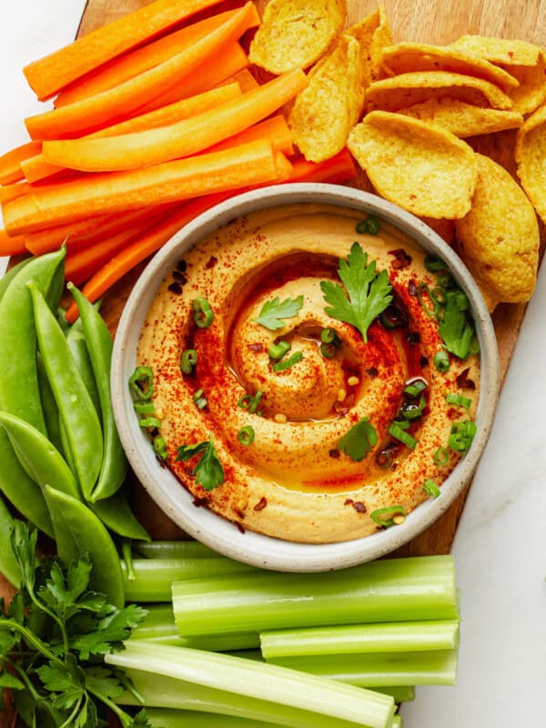 buffalo hummus on a wood board with vegetables and chips