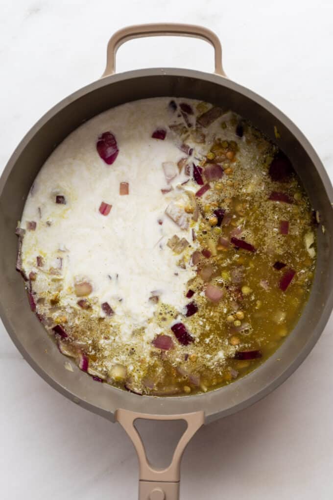 lentils, onions, broth and coconut milk simmering in a large pan