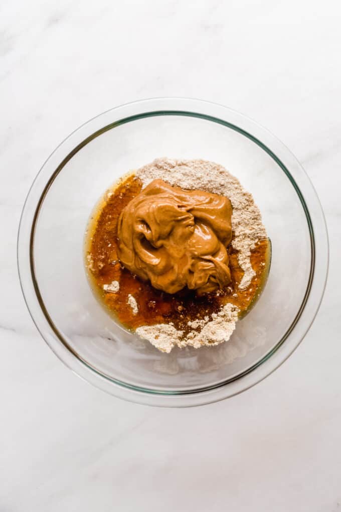 peanut butter, protein powder, almond flour and maple syrup in a mixing bowl