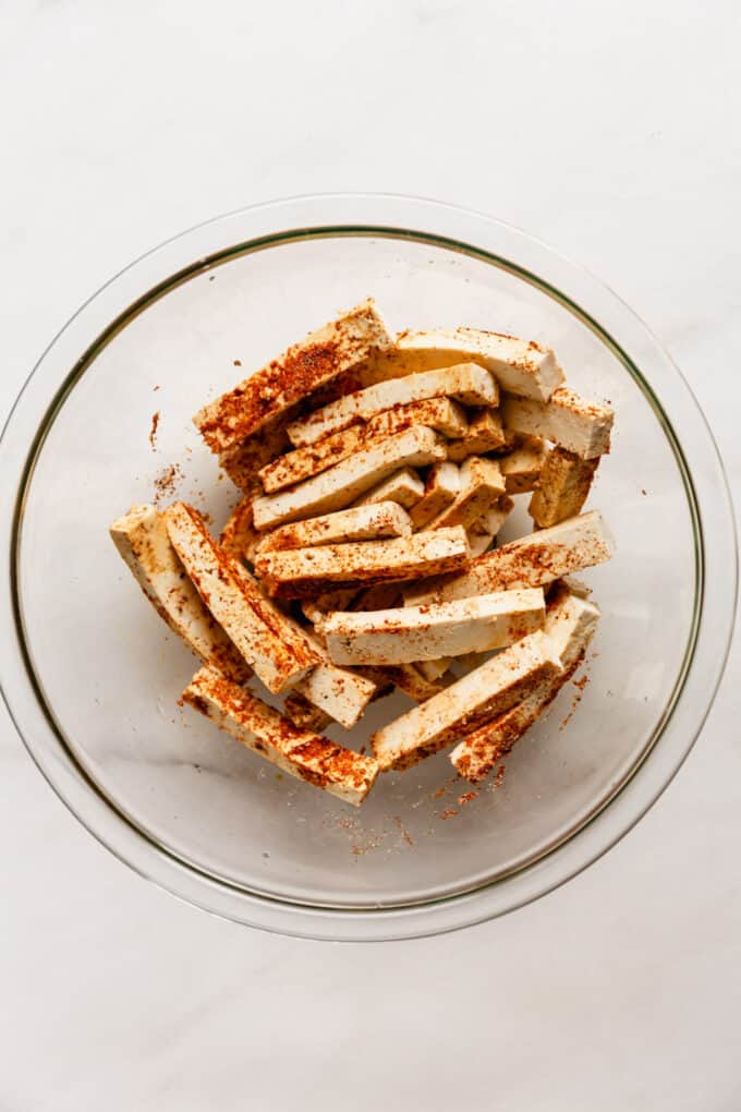tofu strips in a mixing bowl with seasoning