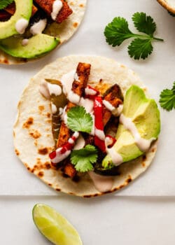 a tofu fajita with avocado and chipotle crema on a taco shell