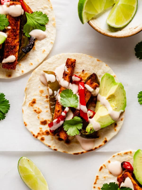 tofu fajitas on taco shells topped with chipotle crema