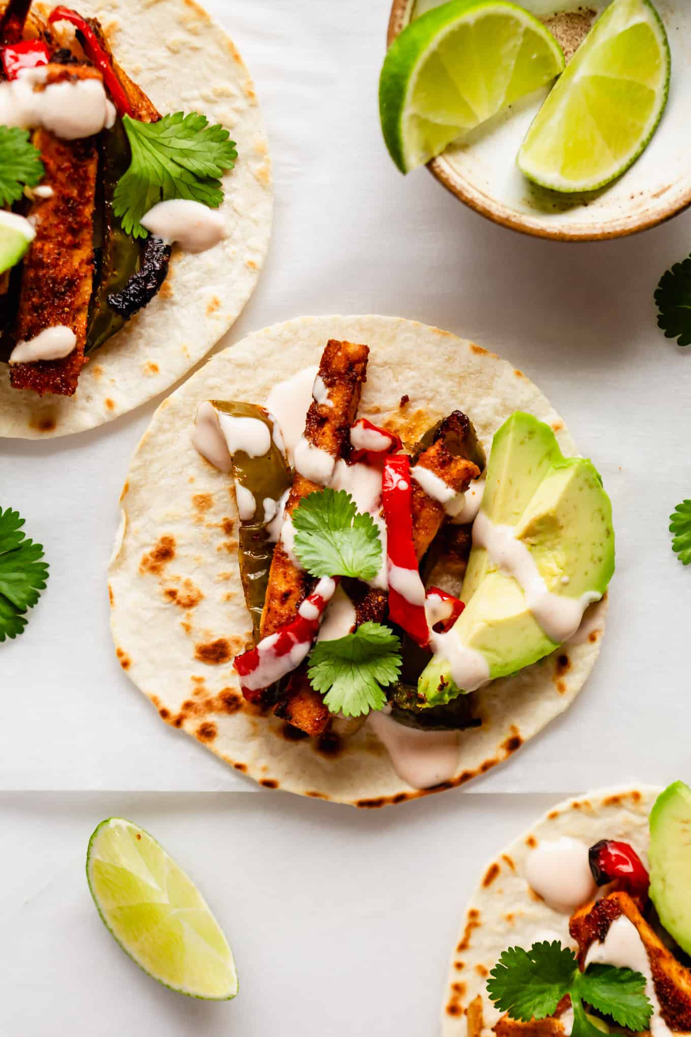 tofu fajitas on taco shells topped with chipotle crema