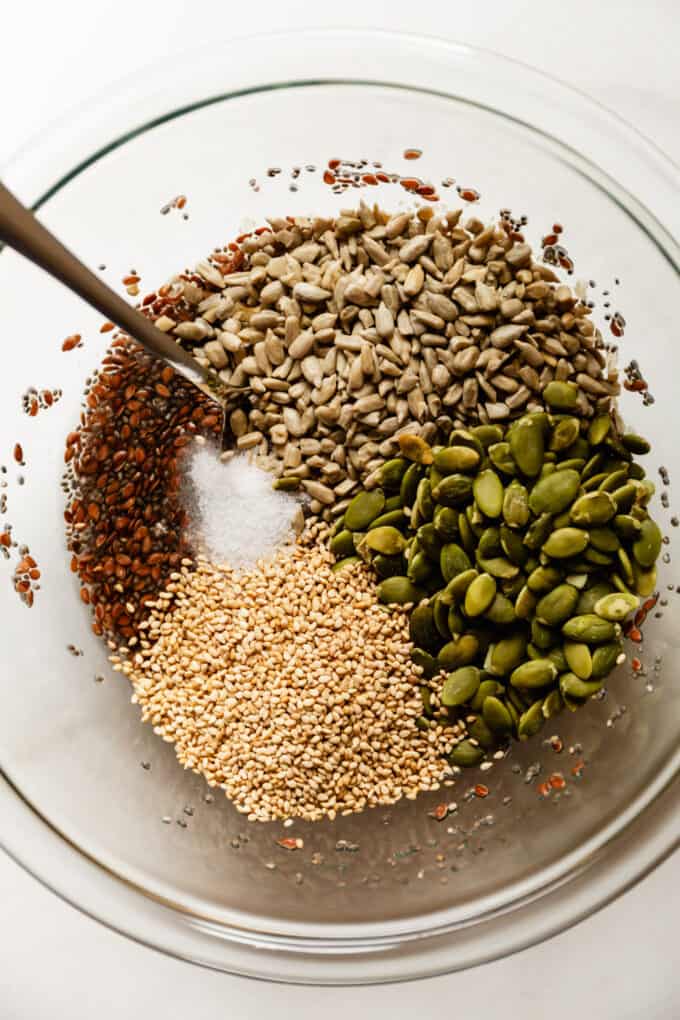 seeds in a clear mixing bowl with a spoon