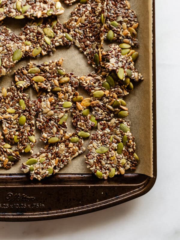 5 seed crackers broken into pieces on a baking sheet