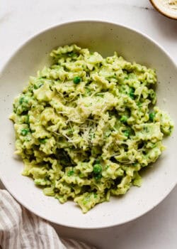 ricotta and pea pasta in a bowl topped with parmesan cheese