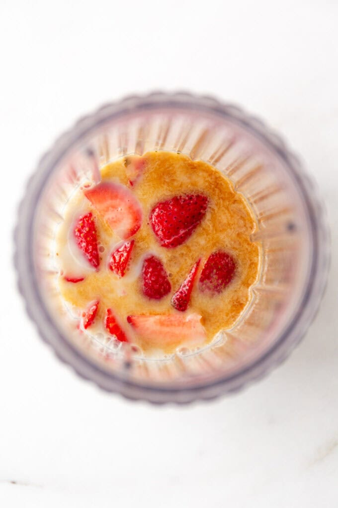 strawberries, maple syrup and almond milk in a blender
