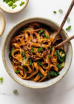 miso noodles in a white speckled bowl with wood chopsticks