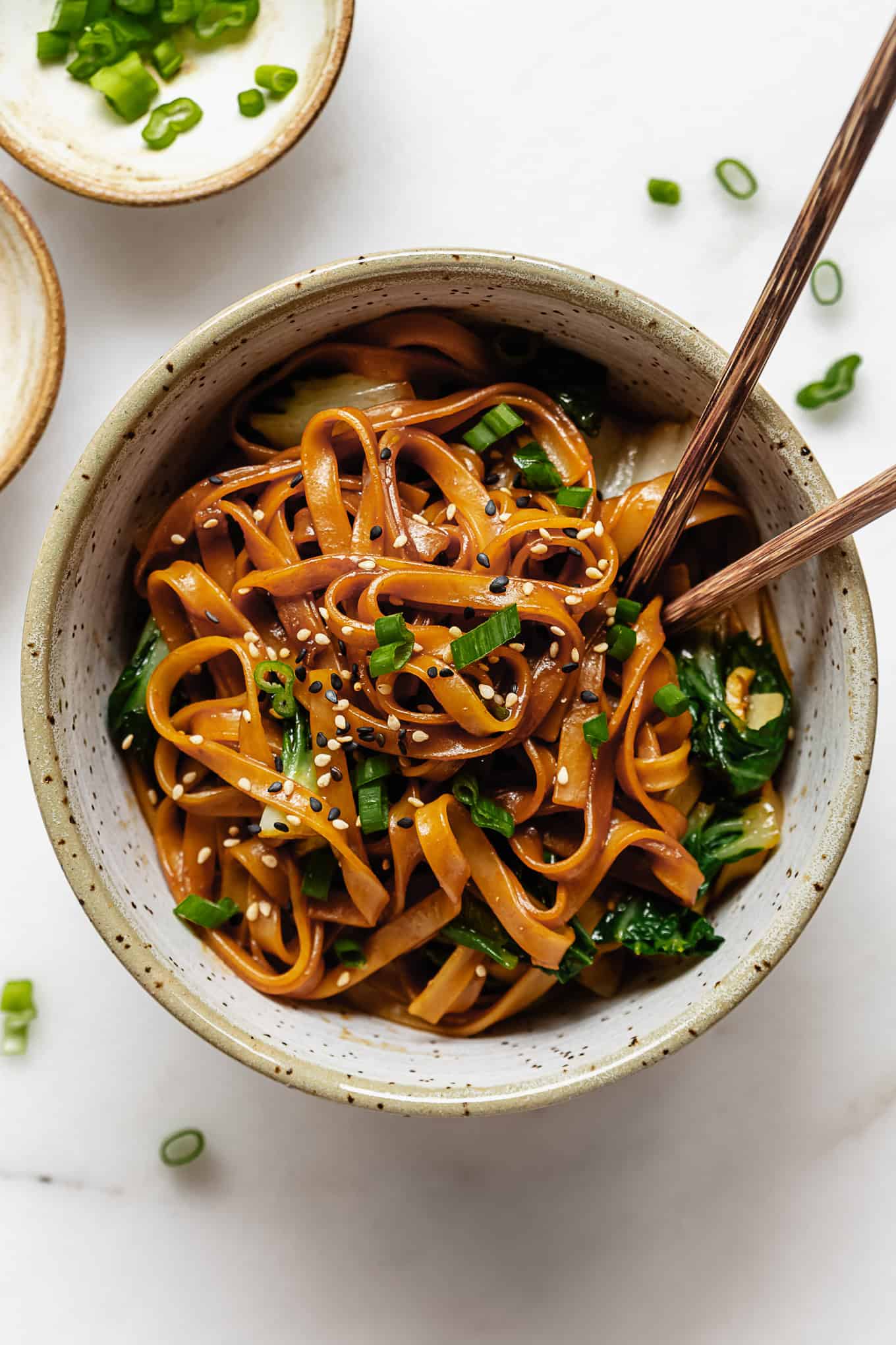 miso noodles in a white speckled bowl with wood chopsticks