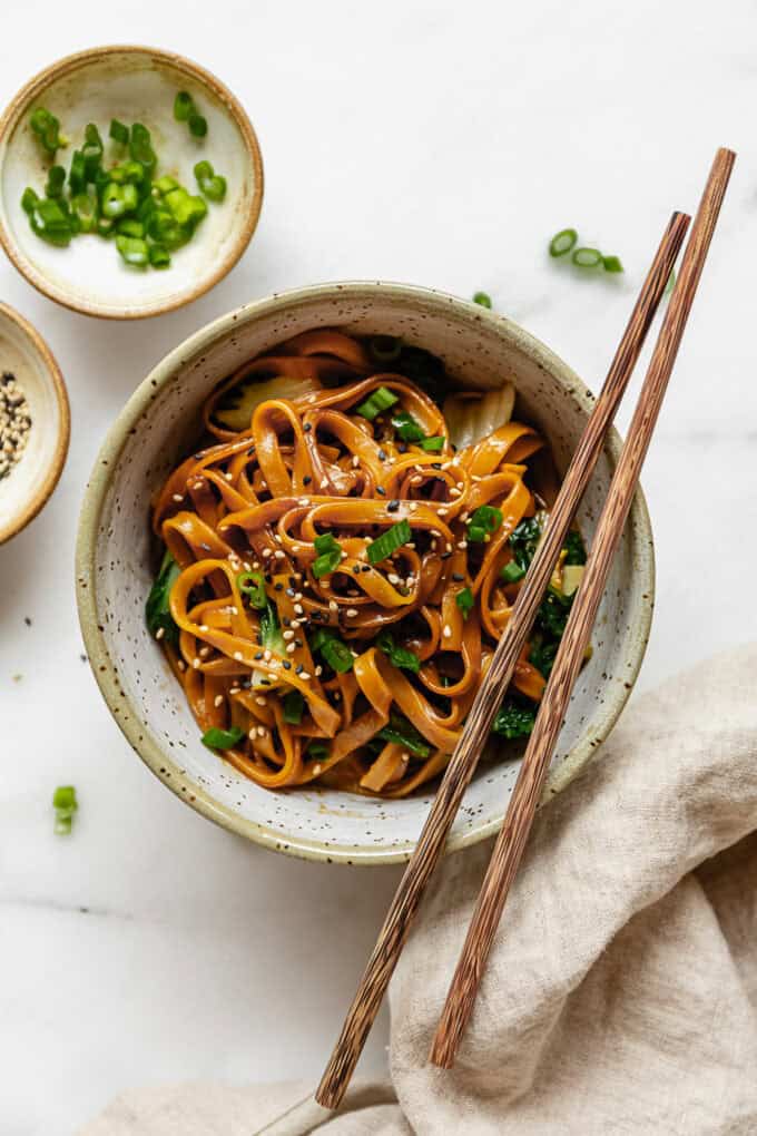 Miso noodles in a bowl with wood chopsticks and a beige napkin on the side