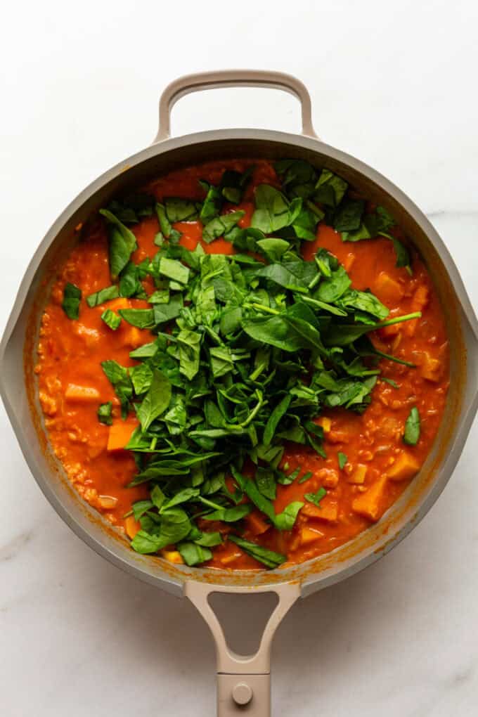 sweet potatoes, lentils and spinach in a taupe pan