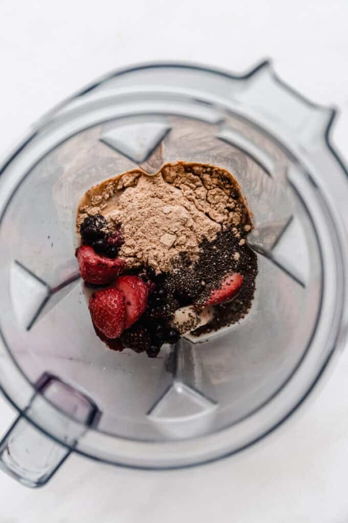 berries, banana, almond milk, chia seeds and protein powder in a blender