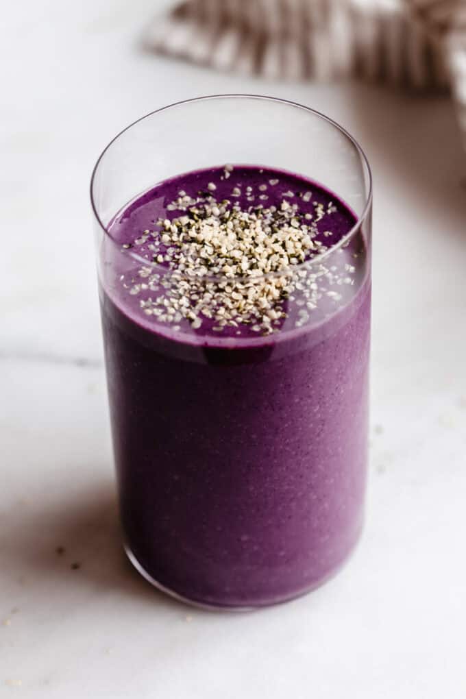 a glass filled with purple berry protein smoothie
