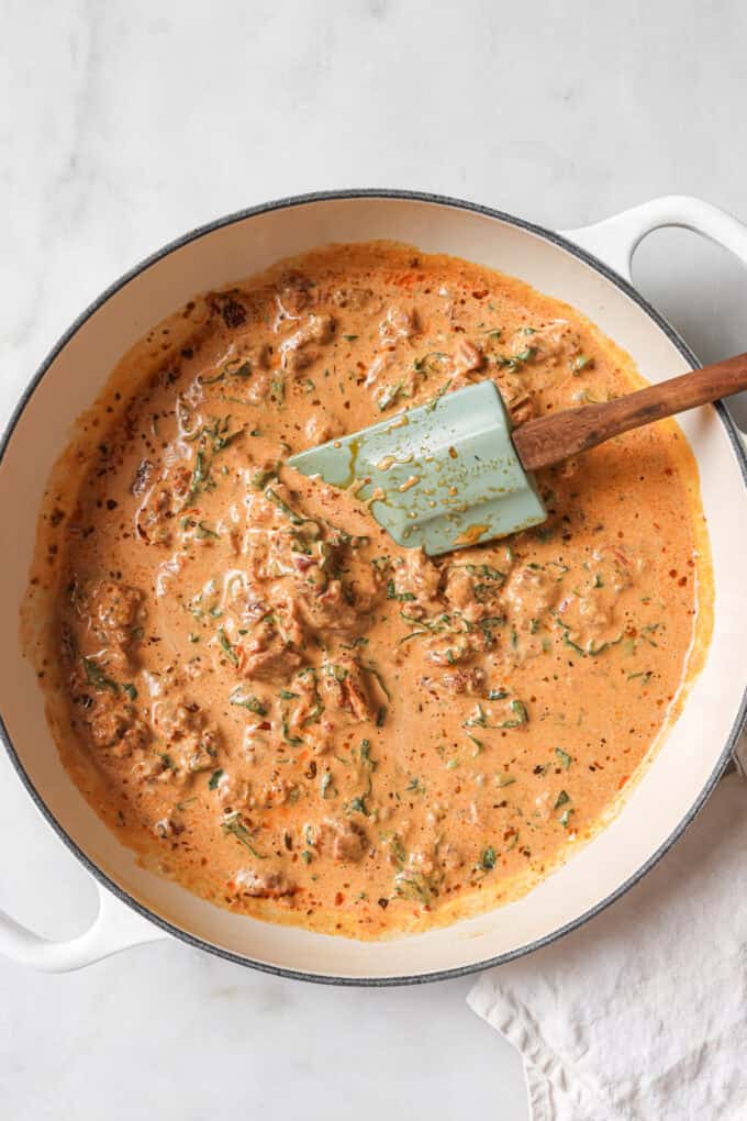 Sundried tomato sauce in a white pot with basil