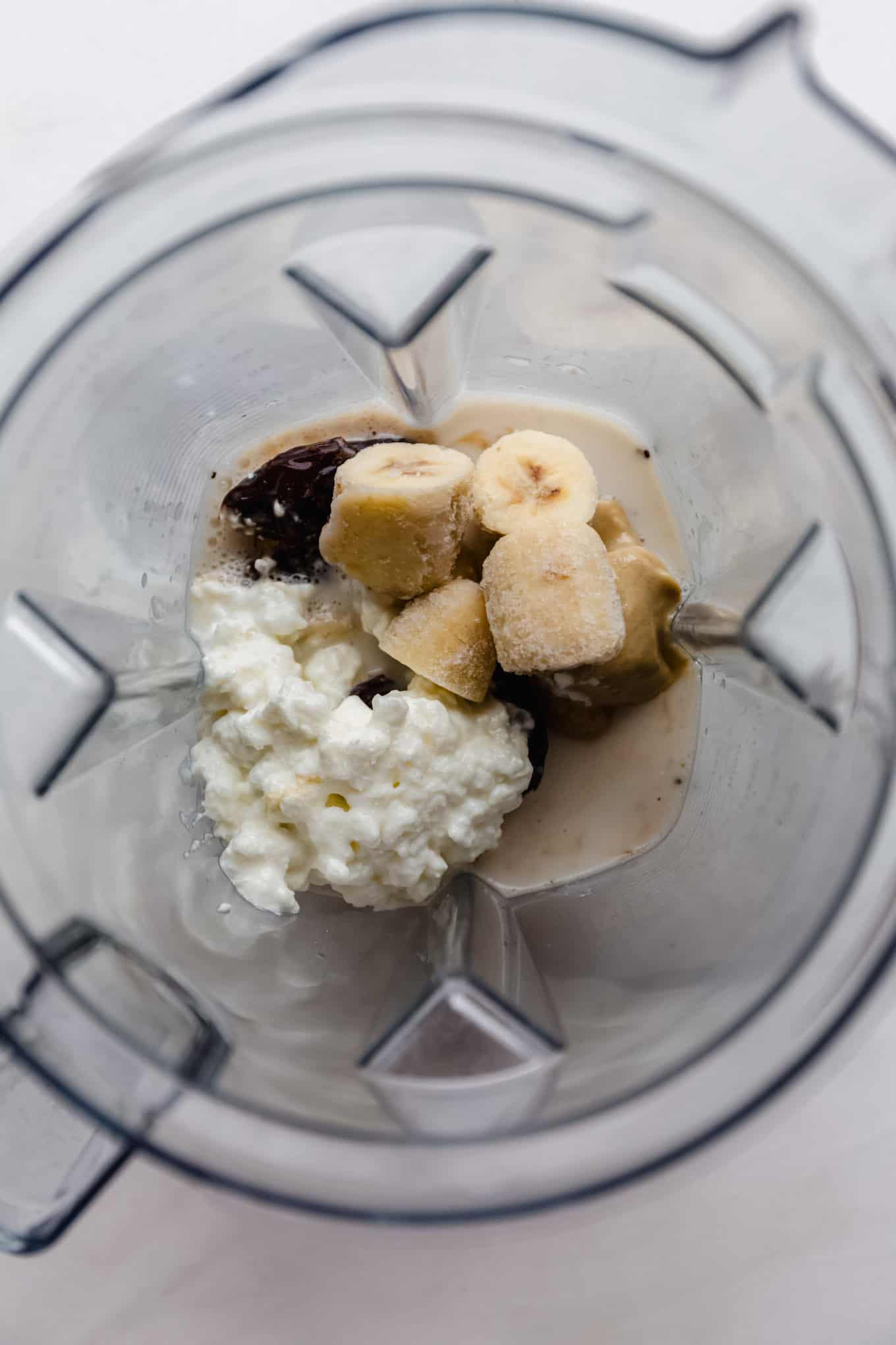 Cottage cheese, banana, dates, tahini and almond milk in a blender.