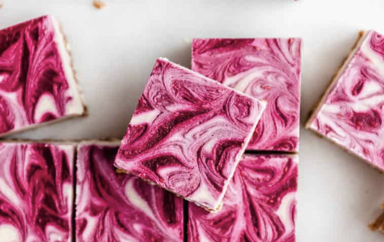vegan raspberry cheesecake bars cut into squares.