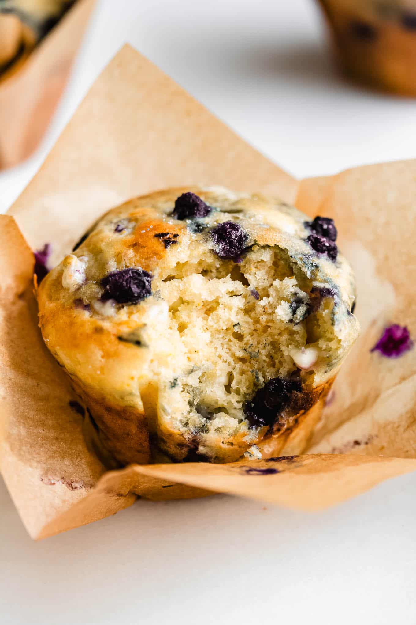 A cottage cheese blueberry muffin with a bite taken out of it