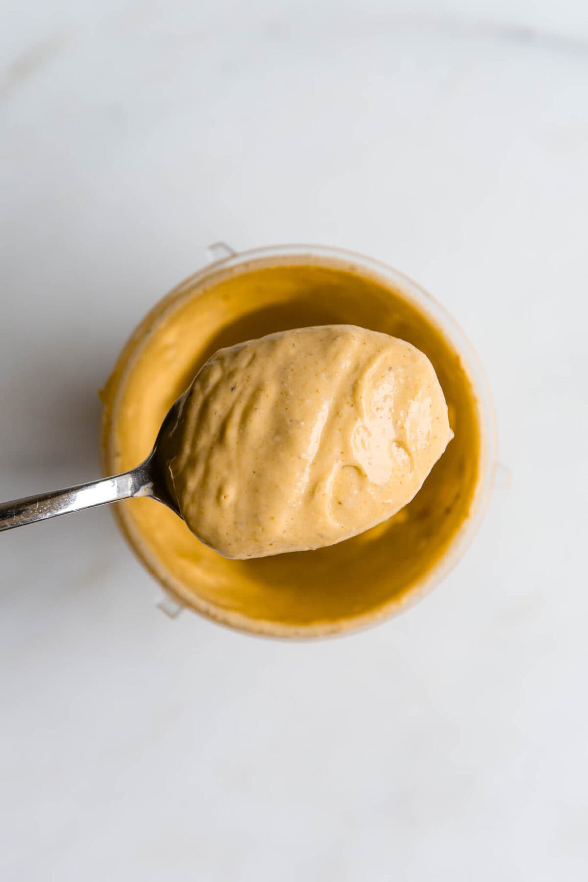 Blended cottage cheese queso on a spoon.