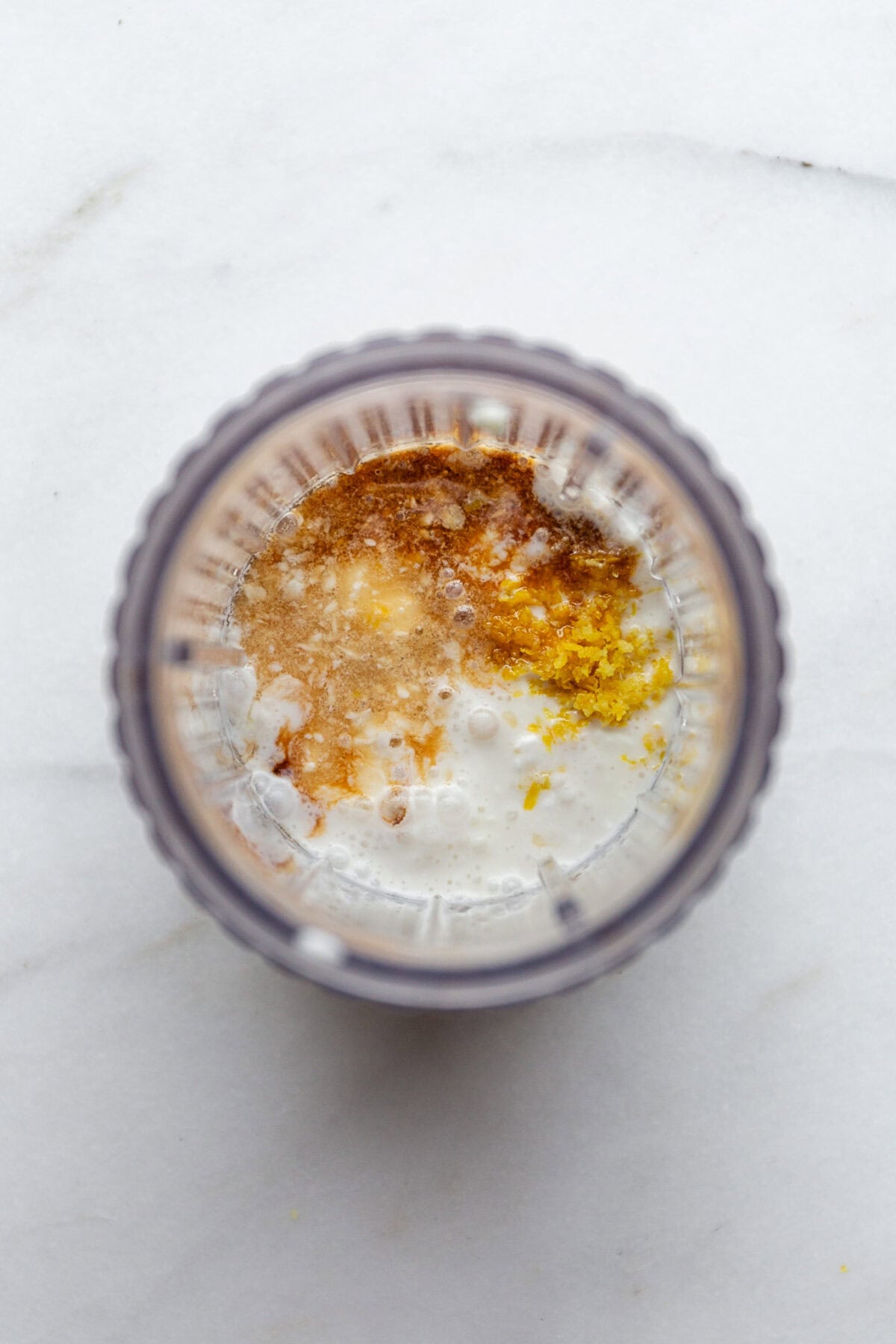 cottage cheese, coconut milk, lemon zest and lemon in a blender container.