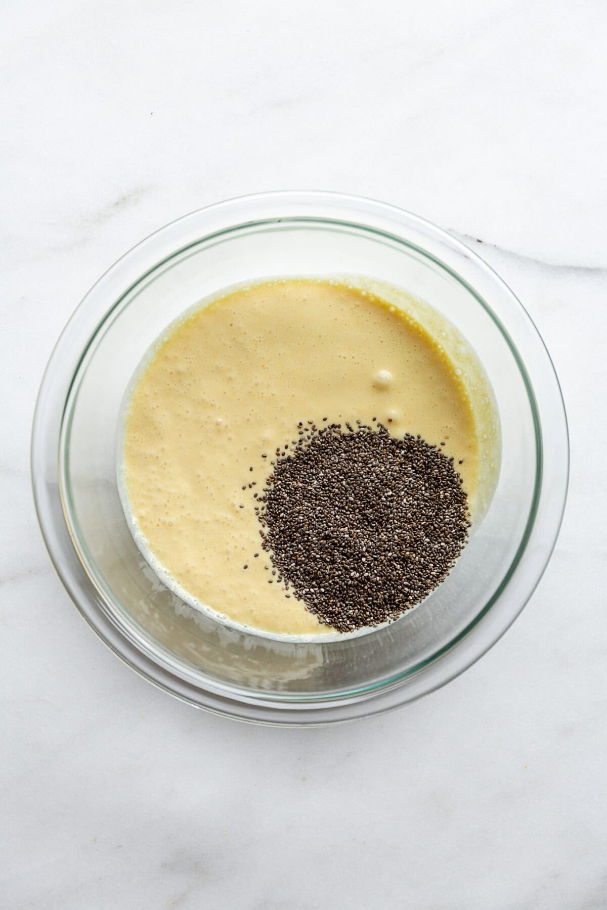 chia seeds and lemon cream in a clear mixing bowl.