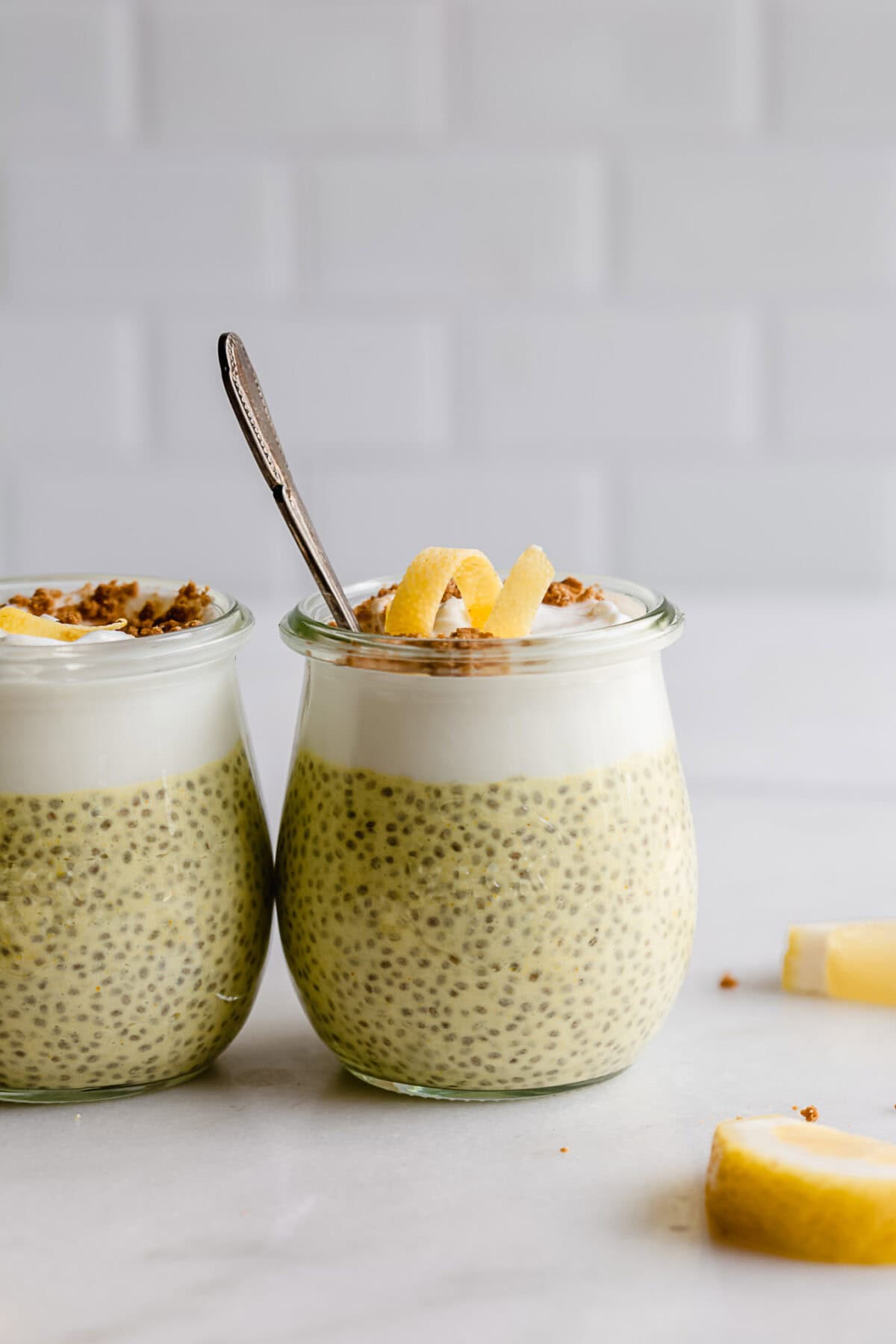 two cups of lemon chia pudding topped with yogurt and lemon zest.