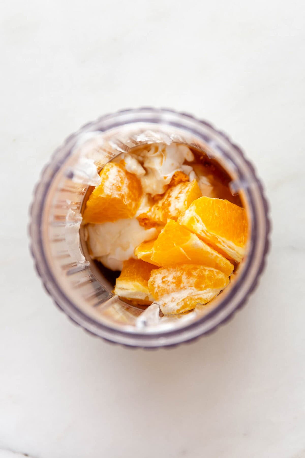 oranges, coconut milk, vanilla and maple syrup in a blender container.